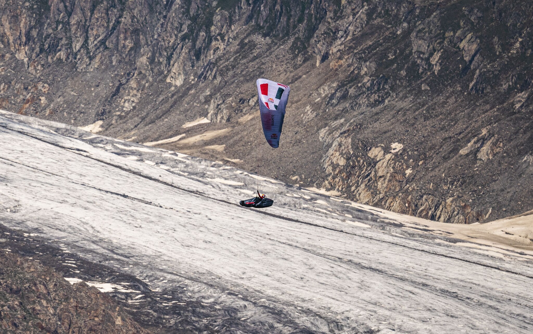 Paul Guschlbauer (AUT1) performing during the Red Bull X-Alps above Fiesch, Bettmeralp / Switzerland on 25-June-2021. In this endurance adventure race athletes from 18 nations have to fly with paragliders or hike from Salzburg along the alps towards France, around the Mont Blanc back to Salzburg.