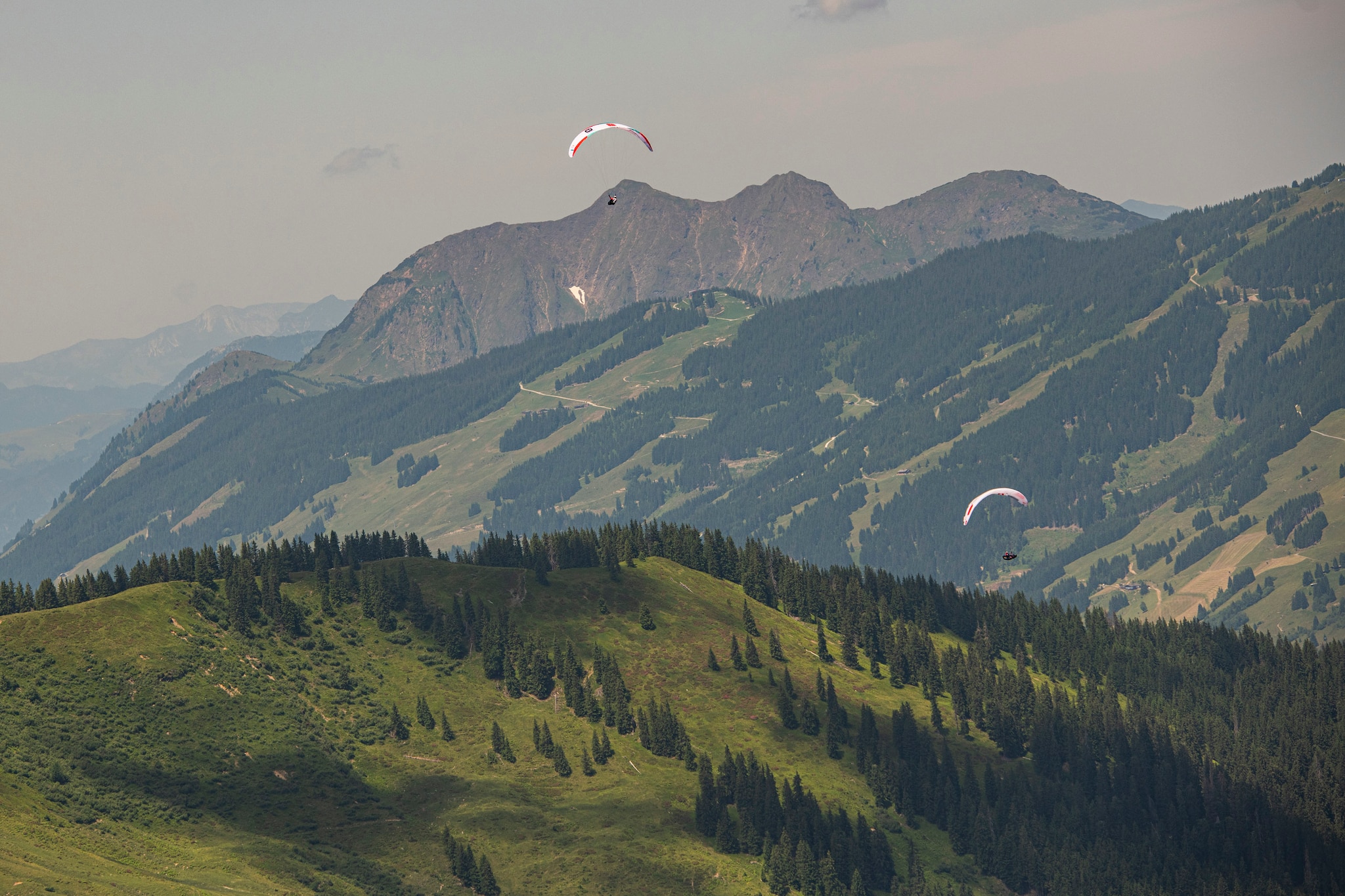 Patrick von Kaenel (SUI2) and Simon Oberrauner (AUT2) racing during the Red Bull X-Alps at Schmittenhöhe / Austria on 29-June-2021. In this endurance adventure race athletes from 18 nations have to fly with paragliders or hike from Salzburg along the alps towards France, around the Mont Blanc back to Zell am See.